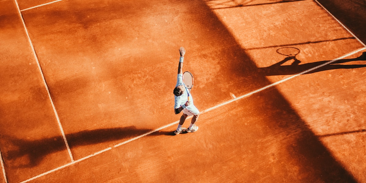 Tennis player serving on a clay court